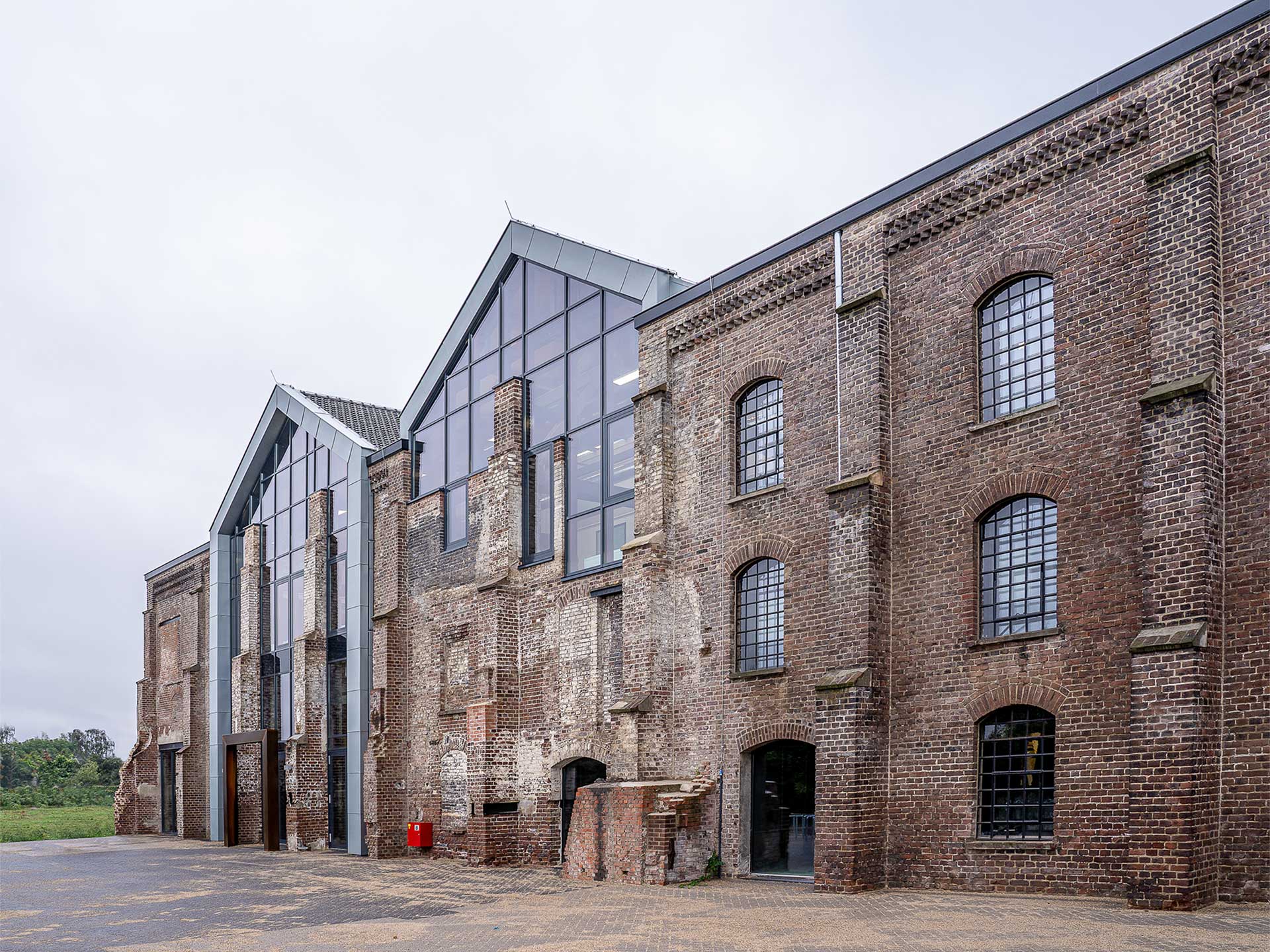 Old brick building with windows and a large door, showcasing facade retention in its historic architecture.