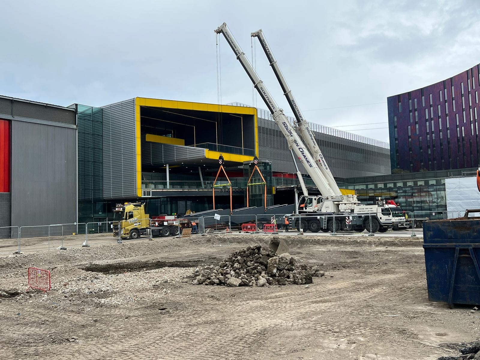 A crane dismantles a building under construction, showcasing the ongoing demolition process.